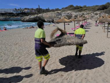 Els treballadors de la SAM instal·lant gandules i para-sols. 