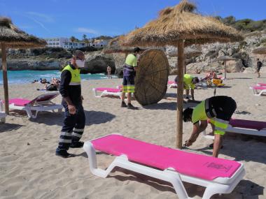 Els treballadors de la SAM instal·lant gandules i para-sols. 