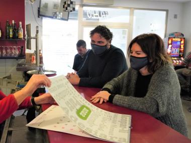 La directora de l’Escola Municipal de Mallorquí, Margalida Rosselló i el delegat de Política Lingüística, Sebastià Llodrà, han obsequiat la propietària del bar Gallo amb el primer dels calendaris de 2022.