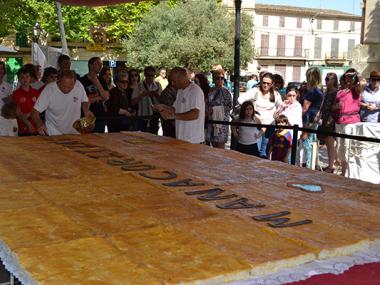 El 'pastís de pobre' més gros i solidari reivindica el comerç local i celebra un dia ple d'activitats en la programació de les Fires i Festes