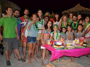 La Sombrillada nocturna de les festes de s'lllot uneix tota una munió de veïns per sopar i gaudir de la nit damunt l'arena