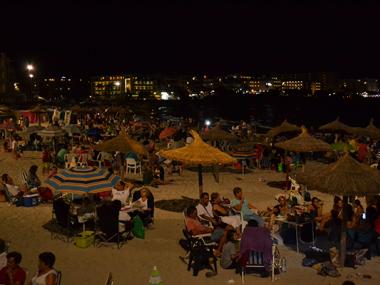 La Sombrillada nocturna de les festes de s'lllot uneix tota una munió de veïns per sopar i gaudir de la nit damunt l'arena