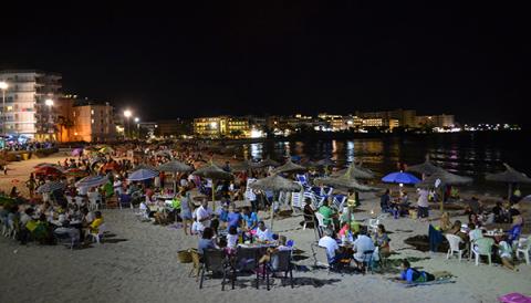 La sombrillada nocturna de les festes de s’Illot uneix generacions de silloters i silloteres en el sopar a la platja